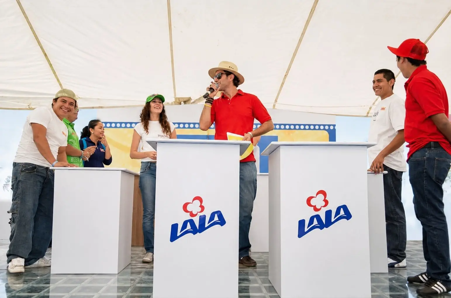 Participantes y conductor frente a módulos de juego durante 100 Mexicanos Dijeron