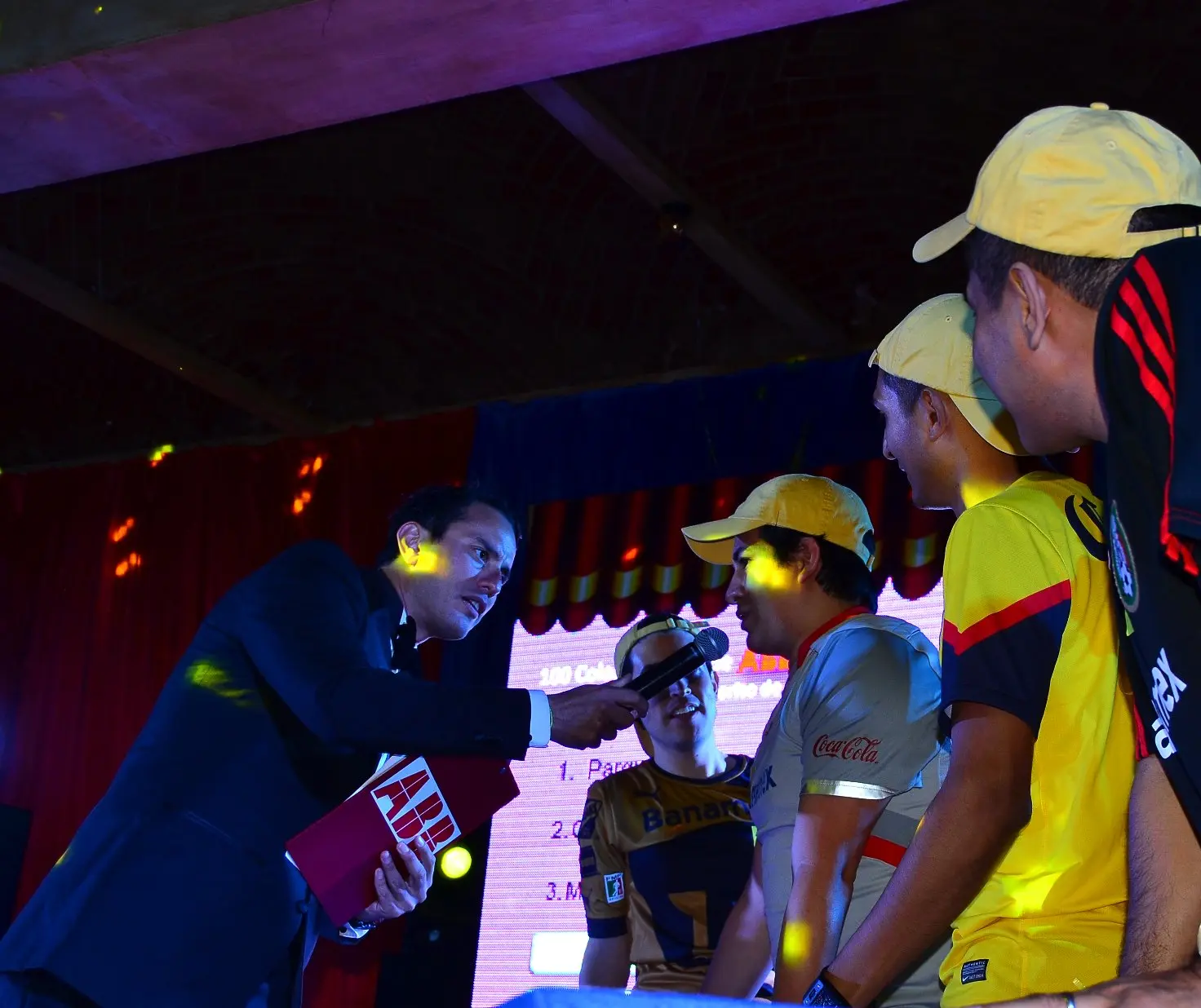Conductor entrevistando a participantes durante una dinámica por equipos