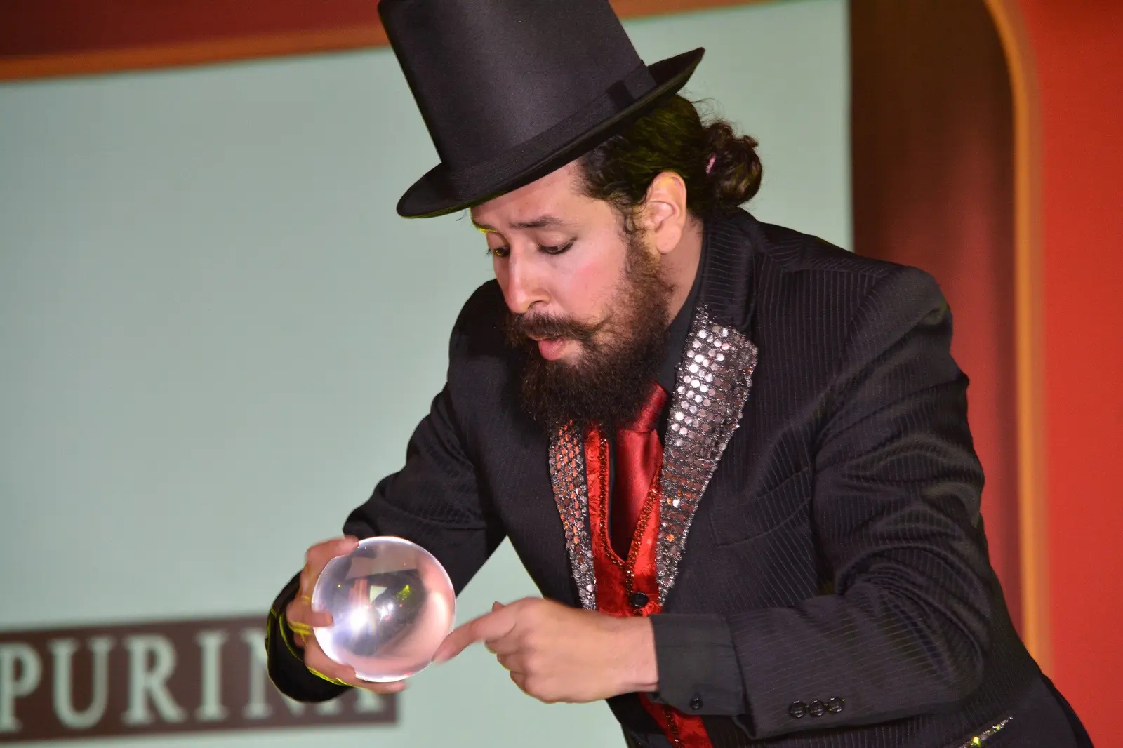 Artista realizando un acto con una esfera transparente durante una producción de Circo