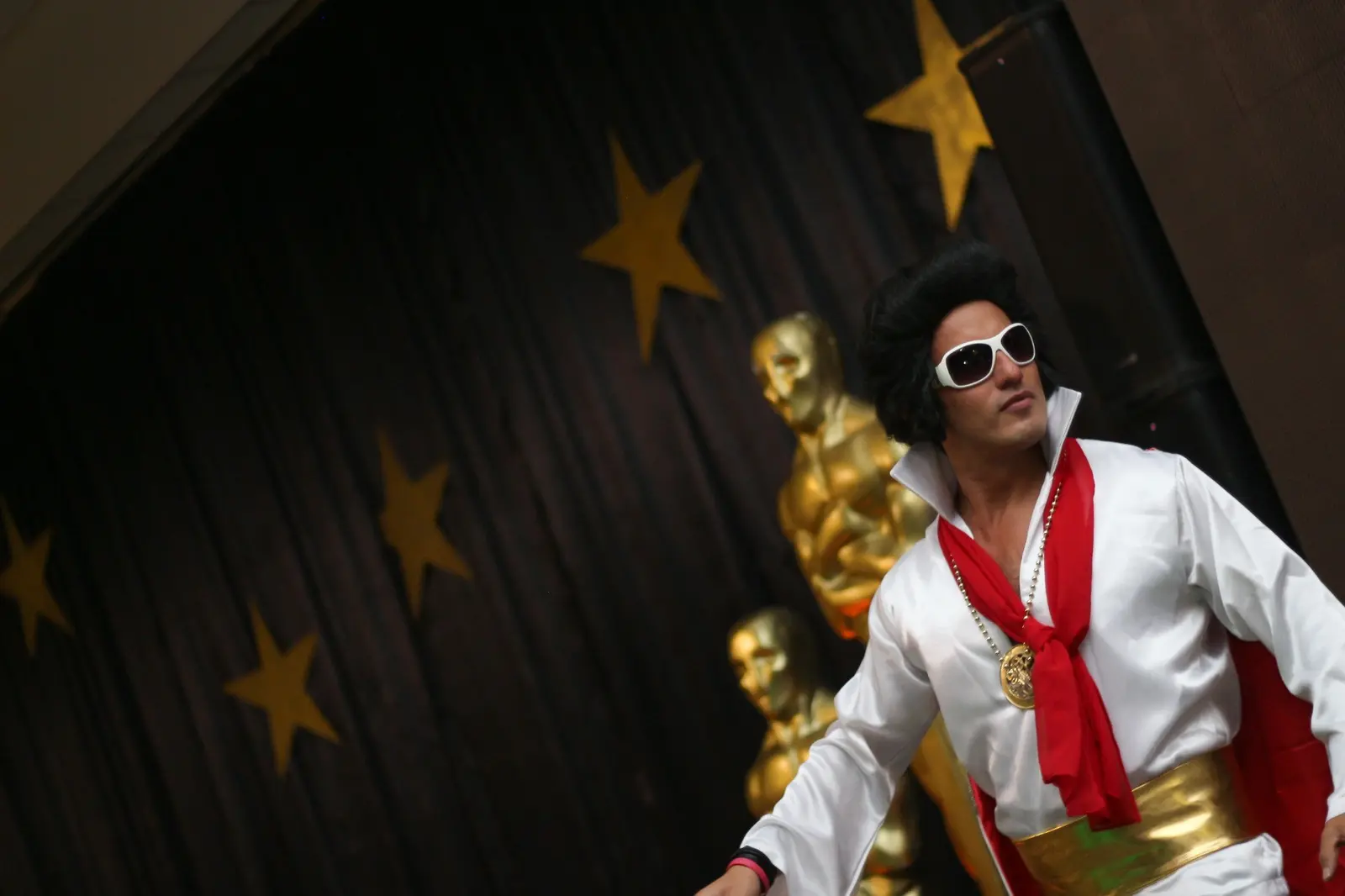 Artista caracterizado con vestuario inspirado en Elvis sobre un escenario
