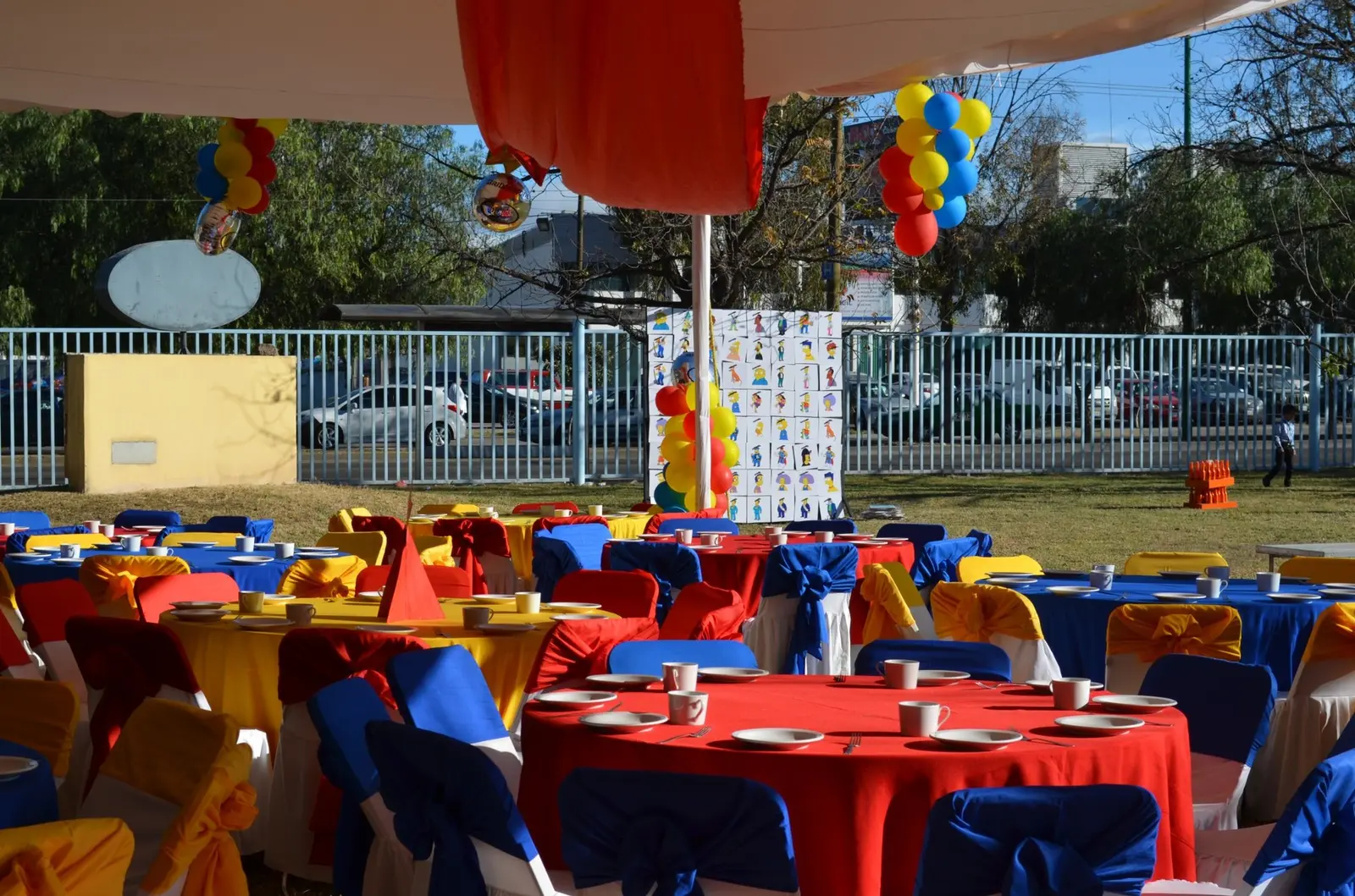 Mesas decoradas con manteles de colores y globos dentro de un montaje del Día de la Familia