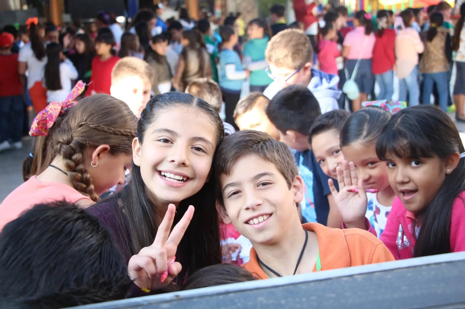 Grupo de niñas y niños sonriendo frente a cámara durante el evento