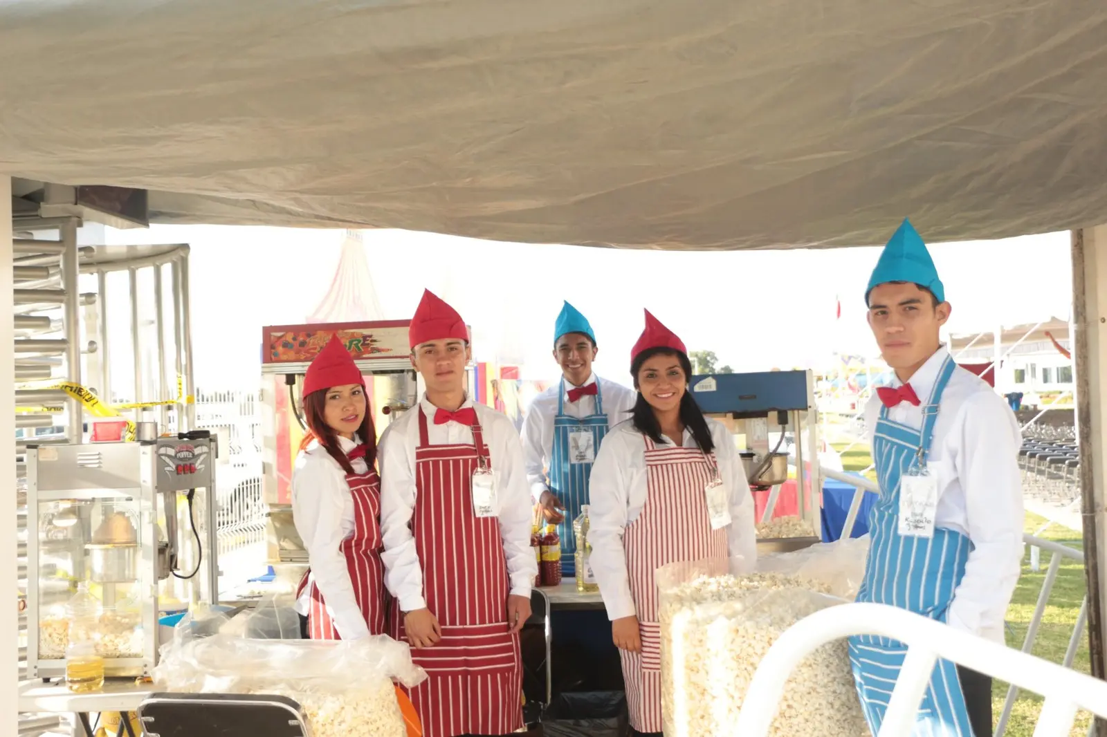 Personal de alimentos atendiendo una estación de snacks y palomitas en el evento