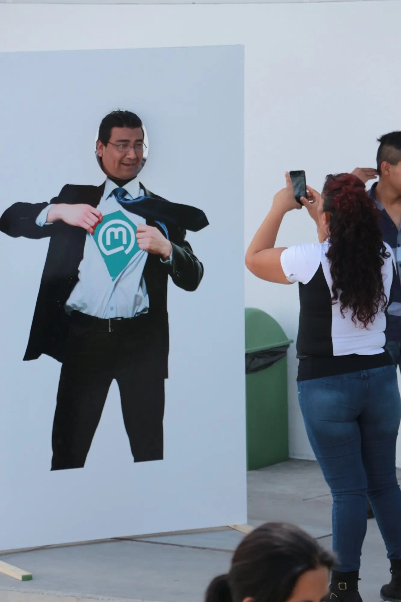 Invitado interactuando con una activación fotográfica de superhéroe durante un Día de la Familia
