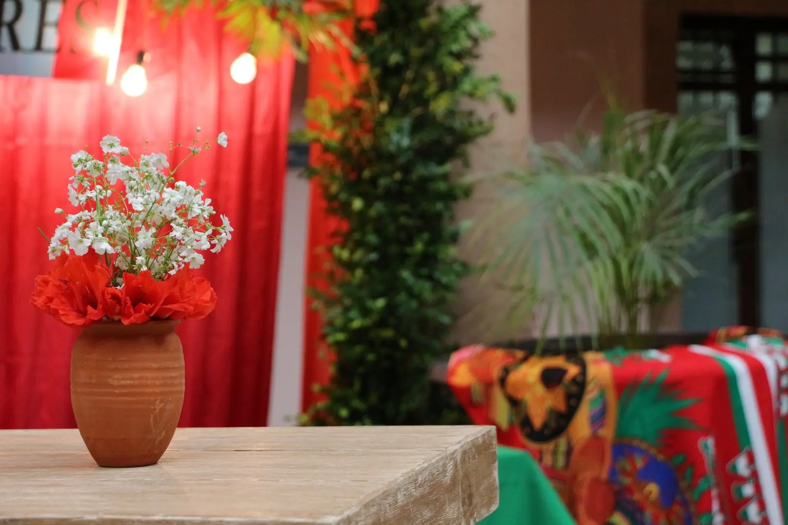 Detalle de ambientación mexicana con flores, textiles y mobiliario