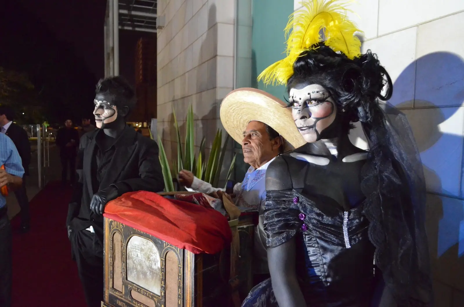 Personajes caracterizados como calaveras junto a un organillero en una experiencia mexicana