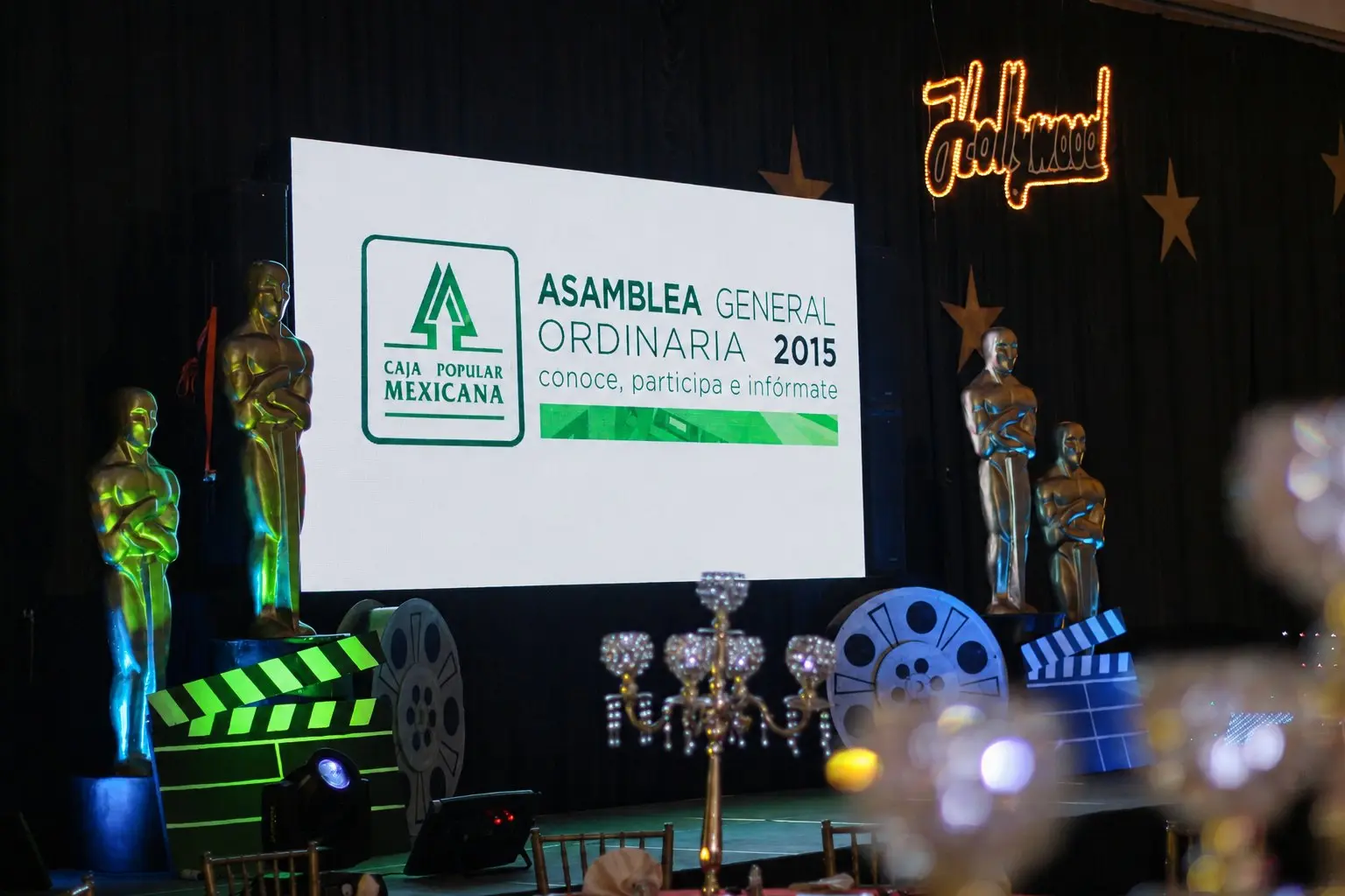 Escenario de Óscares — Hollywood con pantalla de Caja Popular Mexicana, estatuillas y elementos cinematográficos