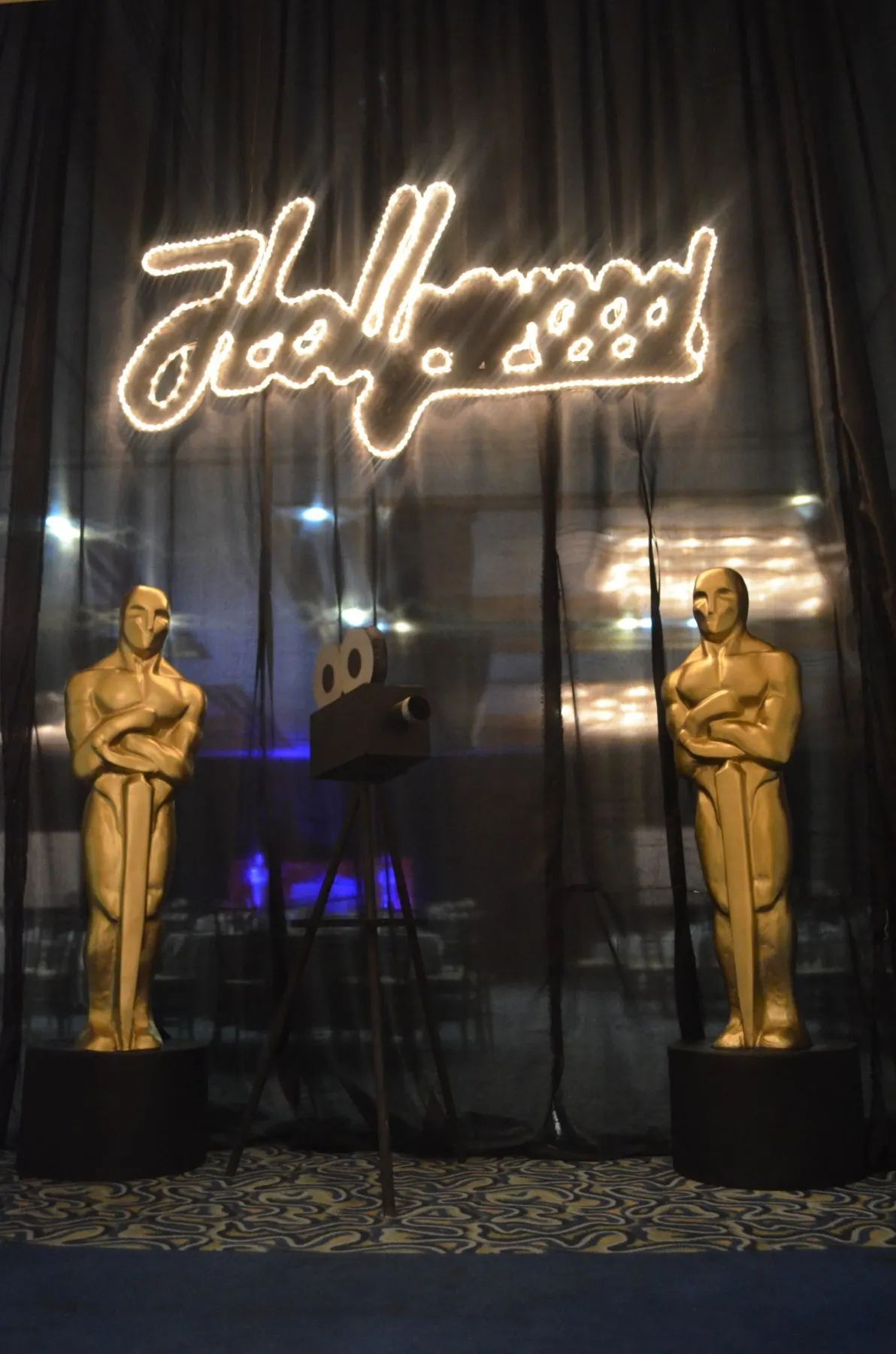 Montaje de Óscares y Hollywood con letrero luminoso, estatuillas doradas y cámara de cine
