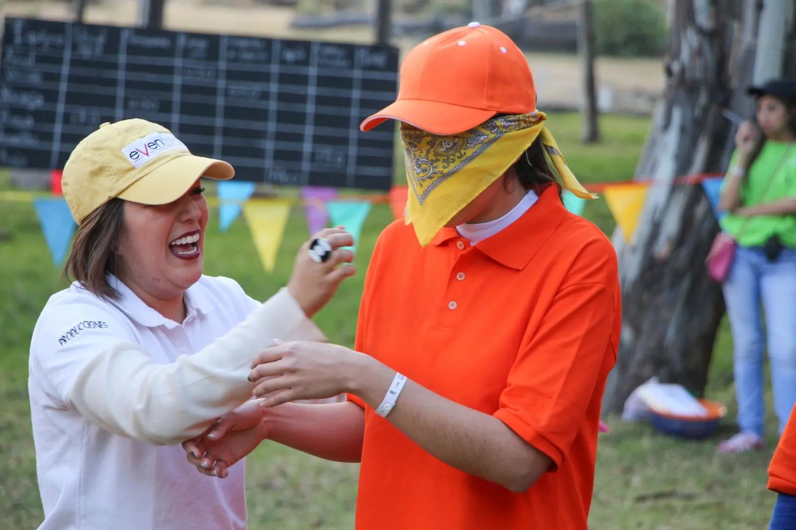 Facilitadora guía a una participante con los ojos vendados durante una actividad de integración