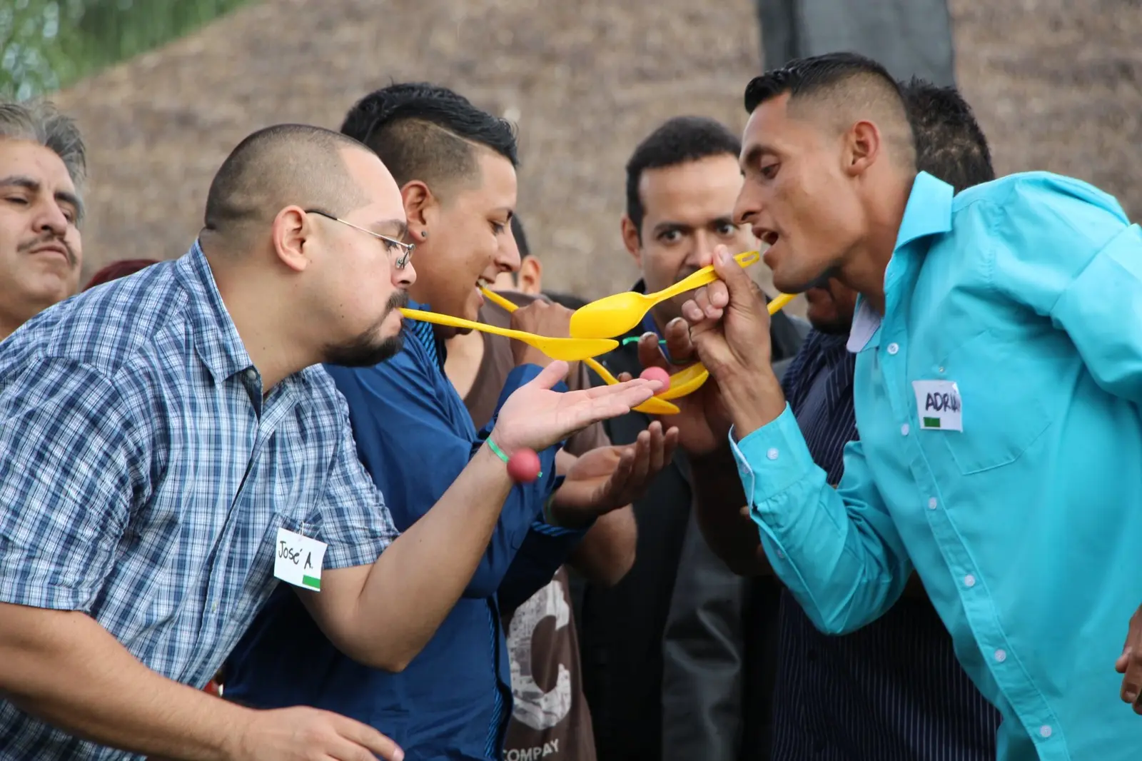 Grupo coordinándose para trasladar pelotas con cucharas durante una actividad de integración