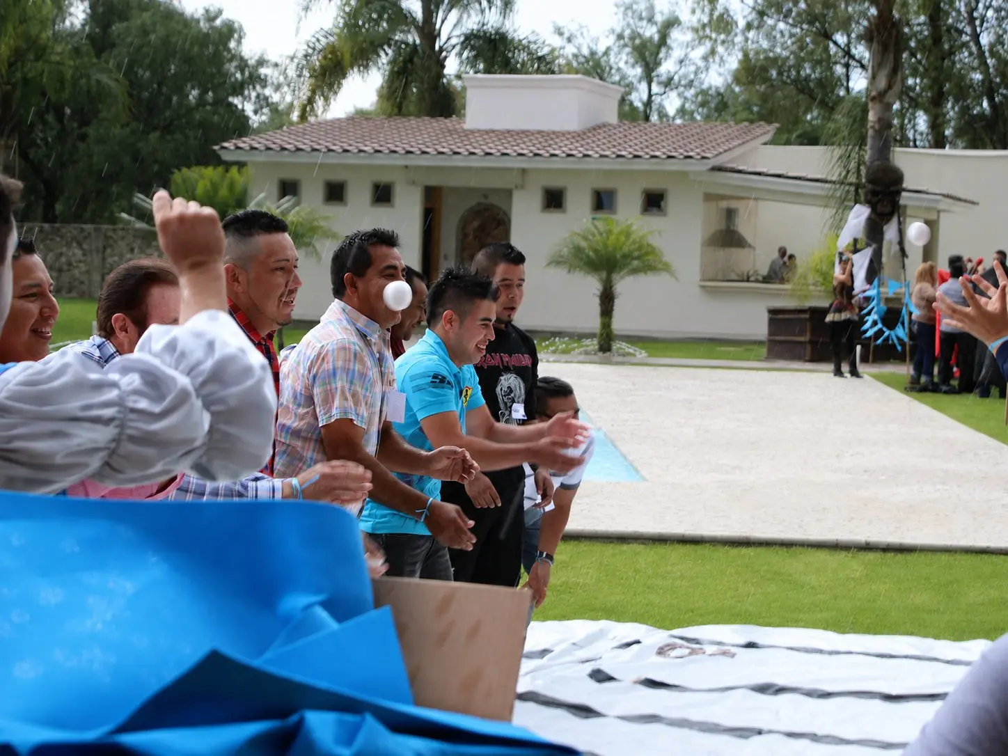 Participantes coordinándose para lanzar pelotas durante una dinámica de Team Building al aire libre