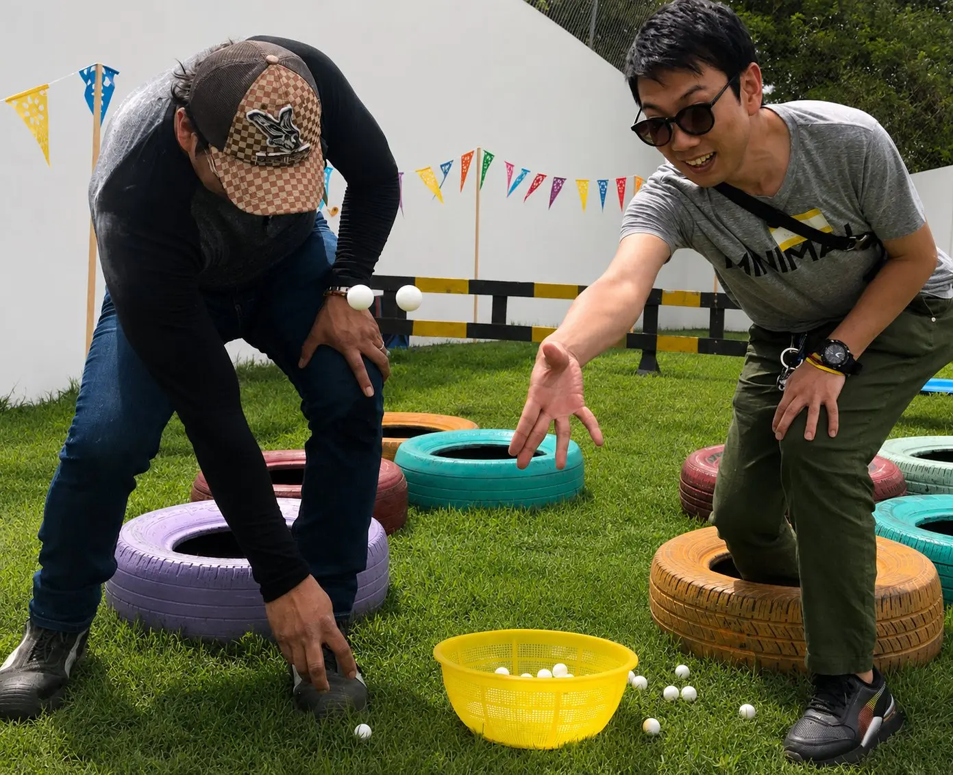 Dos participantes avanzando entre llantas y pelotas durante una actividad de integración