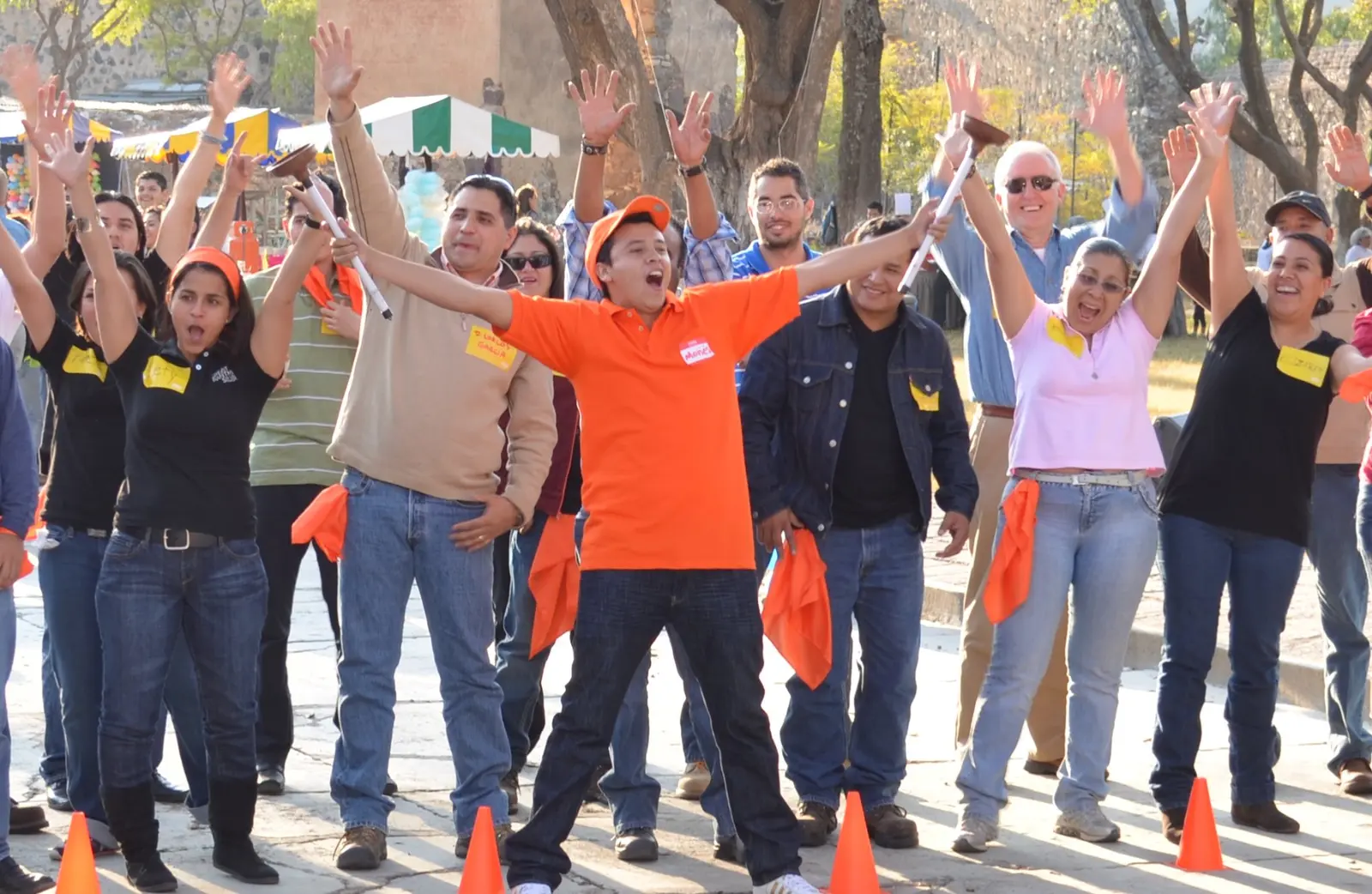 Equipo celebrando con los brazos en alto después de completar una dinámica al aire libre
