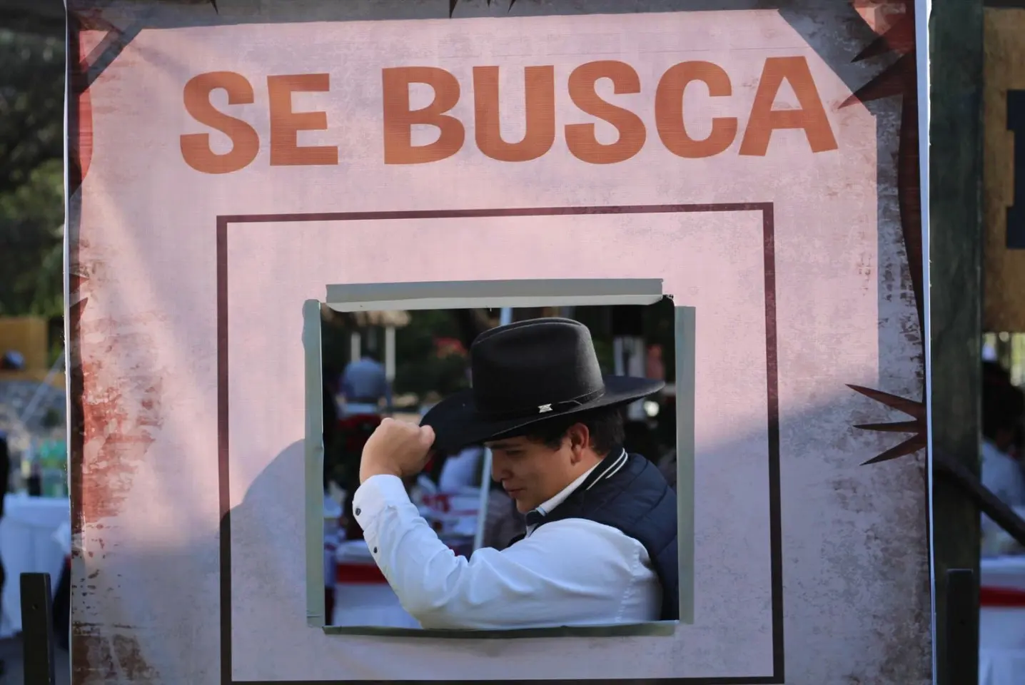 Participante caracterizado posando dentro de un cartel de se busca